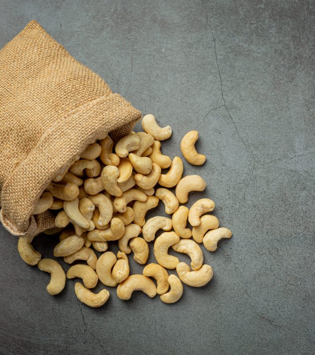 Raw cashews nuts in bag on dark background Raw cashews nuts in bag on dark background